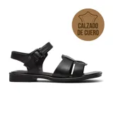 Sandalias bajas de cuero color marrón, con tiras anchas sobre el empeine, tira con hebilla al tobillo y suela plana.