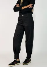 Pantalon de gabardina en color azul oscuro, de corte holgado con botamangas ajustadas mediante elástico.