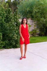 Conjunto de chaleco con botones y bermuda de crepé color rojo. El chaleco es sin mangas y con escote en V. La bermuda es de tiro alto y corte holgado.