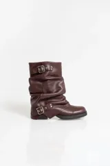 Botas de caña media confeccionadas en cuero color marrón, con diseño arrugado, suela de goma y detalles de hebillas metálicas en la parte superior e inferior.