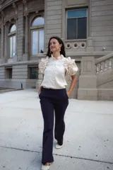 Pantalón de tiro alto con pierna levemente acampanada, confeccionado en lino. Presenta diseño clásico con pinzas delanteras y cierre frontal.