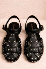 Sandalia tipo guillermina confeccionada en cuero nobuk color chocolate con tachas doradas y hebilla lateral.