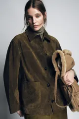Chaqueta de mujer confeccionada en piel de ante 100%, con cuello solapa, manga larga y cierre frontal con botones. Presenta bolsillos de plastrón en el delantero y forro interior.