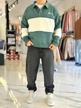 Buzo de cuello polo y medio cierre, con diseño de bloques de color en gris y blanco, de corte oversize y mangas largas.