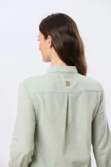 Camisa de lino lisa de manga larga, con cuello clásico y cierre frontal de botones.