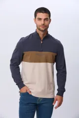 Remera polo de manga larga con diseño de bloques de color en azul marino, marrón y beige. Presenta cuello alto con cierre frontal parcial y estampa frontal con el logo de la marca.