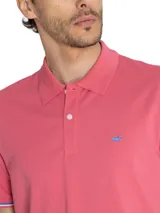 Remera polo de algodón pima color rosado, con cuello y puños acanalados con detalles de líneas contrastantes, cierre frontal con botones y logo bordado en el pecho.