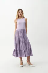 Vestido largo color salmón, con cuerpo ajustado de algodón y falda amplia de rayon, nylon, poliéster y elastano. Presenta un volante plisado en diagonal desde el hombro hasta la cintura.