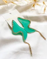 Par de aros colgantes de acrílico color verde agua con forma abstracta y borde con strass dorados.