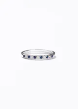 Anillo de plata 925 con engaste continuo de zirconias, alternando piedras azules y transparentes.