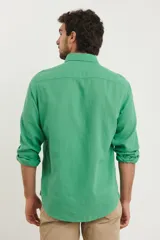 Camisa de manga larga confeccionada en una mezcla de algodón y lino, con cuello abotonado, bolsillo frontal en el pecho y cierre de botones.