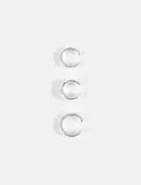 Set de tres earcuffs de metal plateado con diferentes texturas irregulares, diseñados para colocarse en el cartílago de la oreja sin necesidad de perforación.