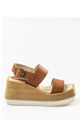 Sandalias de cuero color marrón con plataforma de madera y suela blanca.