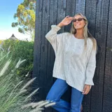 Buzo oversize color beige, con diseño de ochos en el frente y liso en la espalda. Confeccionado en lana y poliamida.