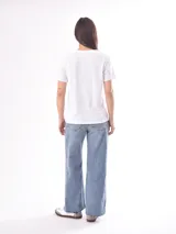 Remera color crudo de corte recto y mangas cortas, con estampado de un pez koi rojo en el pecho. 