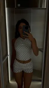 Top halter blanco con lunares negros, de corte ajustado y estilo atemporal.