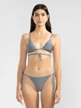 Conjunto de bikini gris con textura acanalada, compuesto por un corpiño triangular con tirantes finos y una bombacha con lazos laterales ajustables.