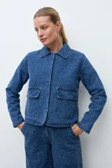 Chaqueta de jean azul con textura de efecto desgastado, cuello clásico y cierre frontal.