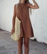 Vestido corto color marrón confeccionado en tusor, con breteles finos y corte holgado.