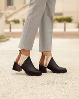 Botines Chelsea de cuero, color negro, con detalles en cuero marrón texturizado (tipo cocodrilo) y paneles laterales en color beige claro. Tienen un taco ancho y cuadrado, y cierre de cremallera lateral en color beige.