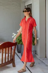 Vestido camisero midi color rojo con ribetes blancos, de corte recto y manga corta.