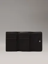 Billetera de plegado triple color negro con estampado de monograma en relieve. Cuenta con seis ranuras para tarjetas, billetero y compartimento monedero con cremallera. Incorpora tecnología de protección RFID.