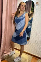 Vestido corto sin mangas con escote en V, confeccionado en denim con un diseño de patchwork en diferentes tonos de azul. Presenta un corte recto y favorecedor.