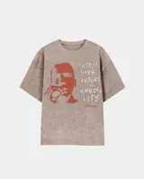 Remera de corte oversize color gris con efecto stone wash. Presenta un estampado frontal en color naranja que incluye el rostro de un personaje y la frase 'Choose your future, choose life' junto con el logo de Trainspotting.