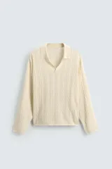 Polo de punto color crema con cuello solapa y abertura frontal, manga larga y diseño de trenzas.