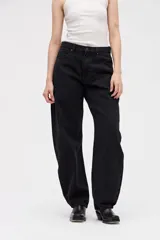 Jean de tiro alto con silueta tipo globo, de cintura ajustada y piernas holgadas que se estrechan hacia el bajo.