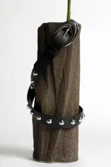 Cinturón negro de cuero sintético con tachas plateadas y hebilla metálica plateada.