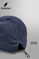 Gorra deportiva de tejido técnico ligero en color azul marino, con visera corta y paneles laterales perforados para mayor ventilación. Presenta logos bordados a tono en el frente.