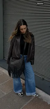 Cartera bandolera de cuero color negro con flecos largos en la parte inferior.