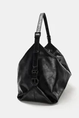 Bolso de hombro de diseño hobo en color negro, con acabado efecto cuero desgastado. Cuenta con asa ajustable, cierre principal mediante cremallera y detalles metálicos en los laterales.