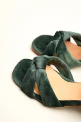 Sandalia de tacón cuadrado medio, confeccionada en terciopelo negro. Presenta un diseño de tiras cruzadas con nudo en la parte delantera y una tira ajustable con hebilla en el tobillo.