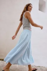 Falda midi de corte en A, color blanco, confeccionada en algodón con cintura elástica de tiro alto y forro interior a tono.