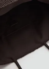Bolso tipo shopper color marrón oscuro, confeccionado con tejido trenzado efecto rafia, con dos asas de mano y diseño rectangular.