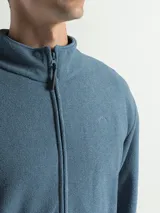 Campera de polar con cuello alto, cierre frontal completo y bolsillos laterales con cierre.