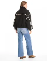 Campera negra de símil corderito, marca Elan. Tiene cuello alto, cierre frontal con solapa y botones, bolsillos inclinados en la parte delantera y ruedo y puños elastizados. Forro interno a tono.
