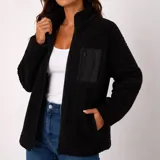 Campera de corderito color negro con cierre frontal completo, cuello alto y un bolsillo frontal en el pecho con cierre.