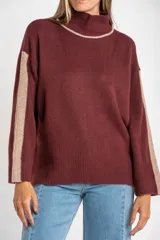 Sweater de punto con cuello alto, diseño oversize y mangas largas. Presenta un contraste de color en el cuello y una franja vertical en las mangas en tono beige.