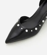 Zapato estilo kitten heel de cuero sintético negro, con punta fina y aplicación de pequeñas tachas metálicas a lo largo del borde superior.
