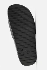 Chancla tipo pala monocolor negra, con suela de goma y tira ancha en el empeine con relieve acanalado.