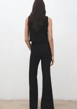 Pantalón de vestir negro de corte recto y tiro medio, confeccionado en poliéster con forro interior.