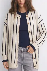 Saco tejido de punto con diseño a rayas verticales, cuello redondo y cierre frontal con botones. Presenta puños con detalle de volados en color azul oscuro.