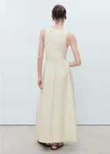 Vestido largo combinado de color marfil, sin mangas, con tirantes anchos, cuello escotado y panel fruncido en la cintura con diseño evasé en la falda.