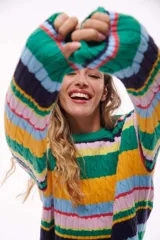 Sweater de punto con rayas horizontales en tonos verde, amarillo, azul, rosa y negro.