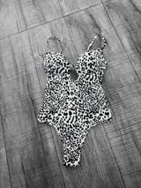 Malla entera con estampado animal print en blanco y negro, con breteles finos y escote pronunciado.