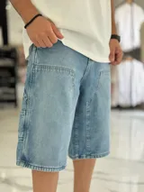 Bermuda de jean estilo carpintero, color celeste, con bolsillos laterales amplios, presilla para herramientas y diseño amplio de corte oversize.
