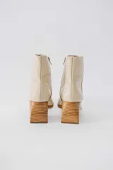 Botas plateadas de cuero con caña media, cierre lateral con cremallera, punta cuadrada y tacón geométrico de madera.